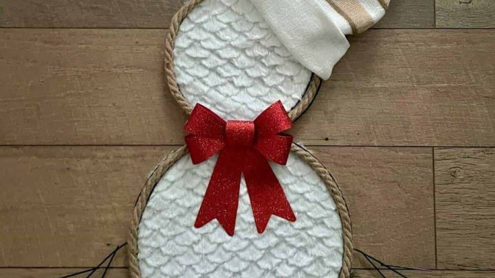 Dollar Tree snowman wreath made from rope and white textured fabric with striped hat