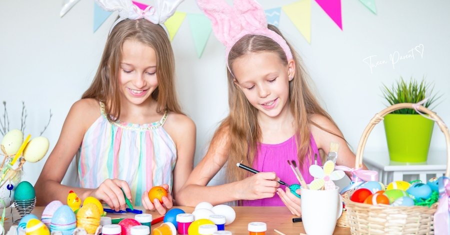 tween girls at a table in brighly colored clothing painting easter eggs and making easter crafts while wearing cute bunny ears