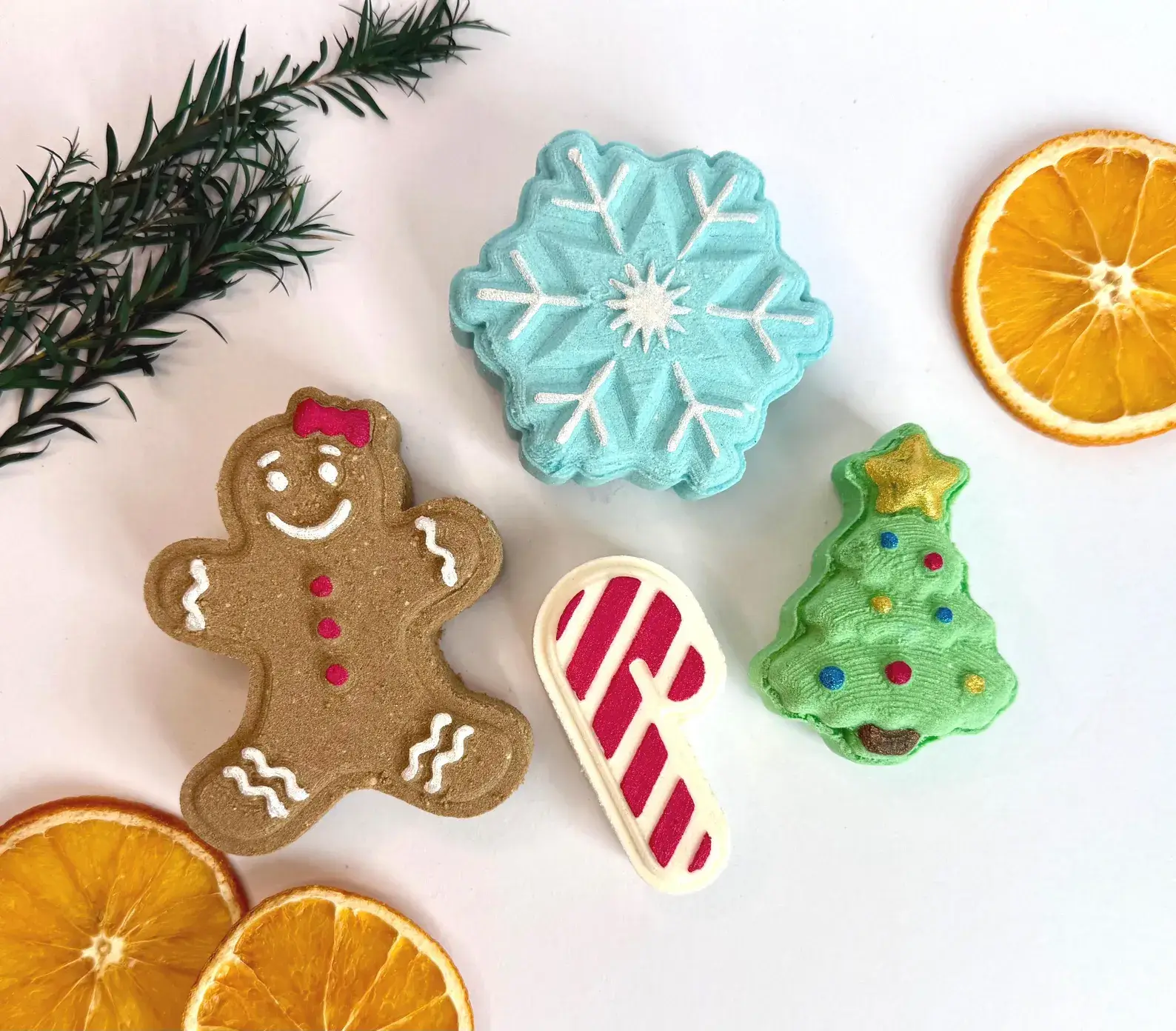 Four festive bath bombs shaped like a gingerbread woman, snowflake, candy cane, and Christmas tree, a fun and relaxing Christmas Eve Box idea for tweens.