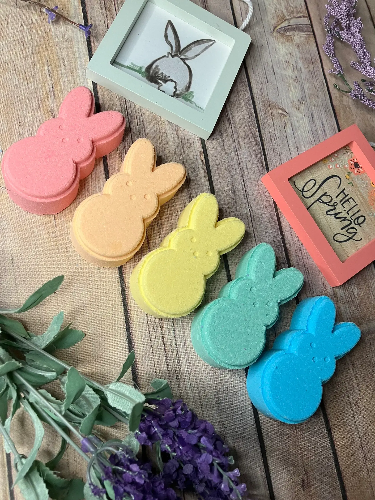 Colorful bunny-shaped Easter bath bombs in pink, orange, yellow, teal, and blue, styled with spring décor, a sweet Easter gift idea for tweens.
